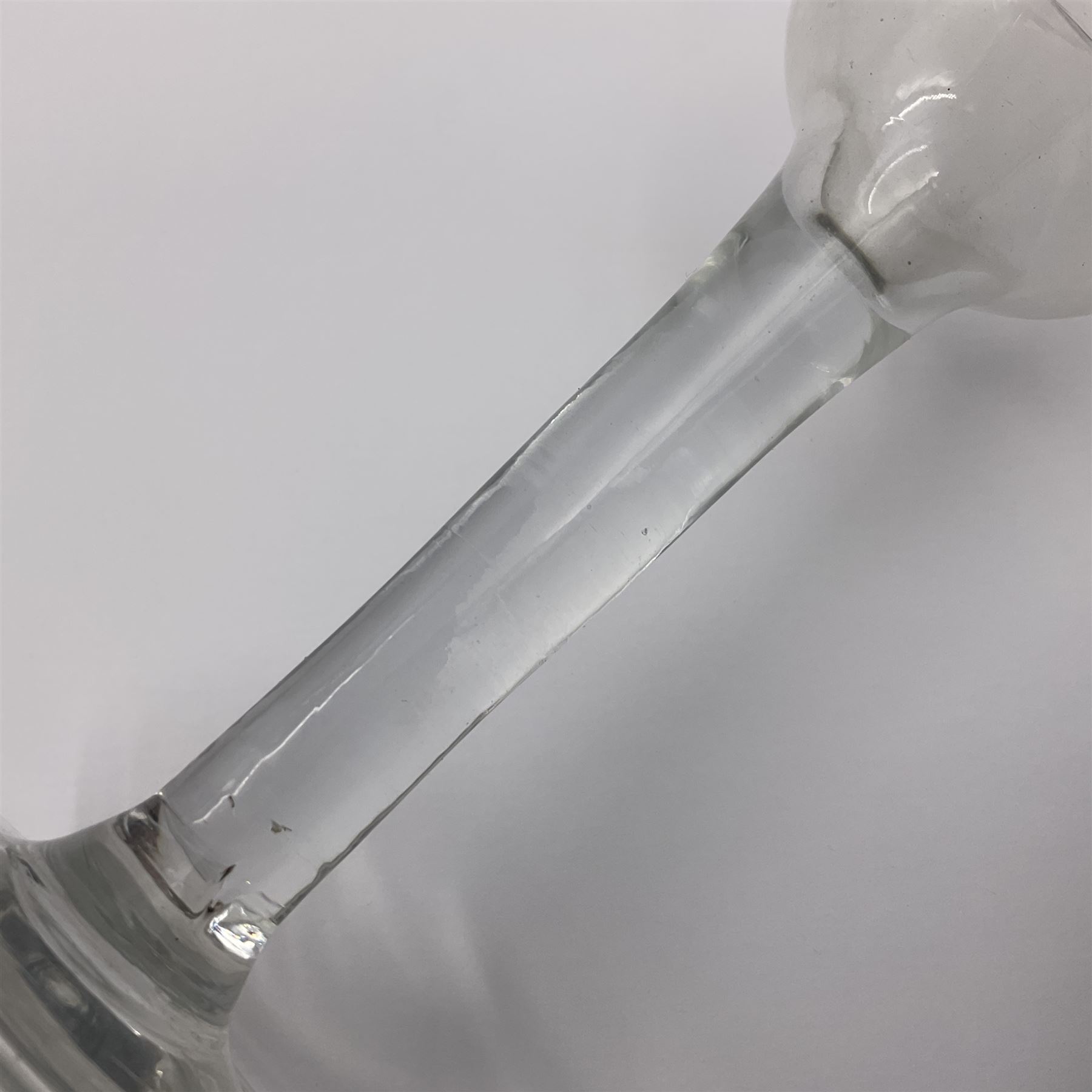 Three 18th century wine glasses comprising a plain stemmed glass with bell shaped bowl and conical folded foot H16cm, another plain stemmed glass with ogee bowl and folded foot and a Continental glass with gilt faceted bowl, decorated with male figure within a landscape, on a clear Silesian seven sided cut stem (3)