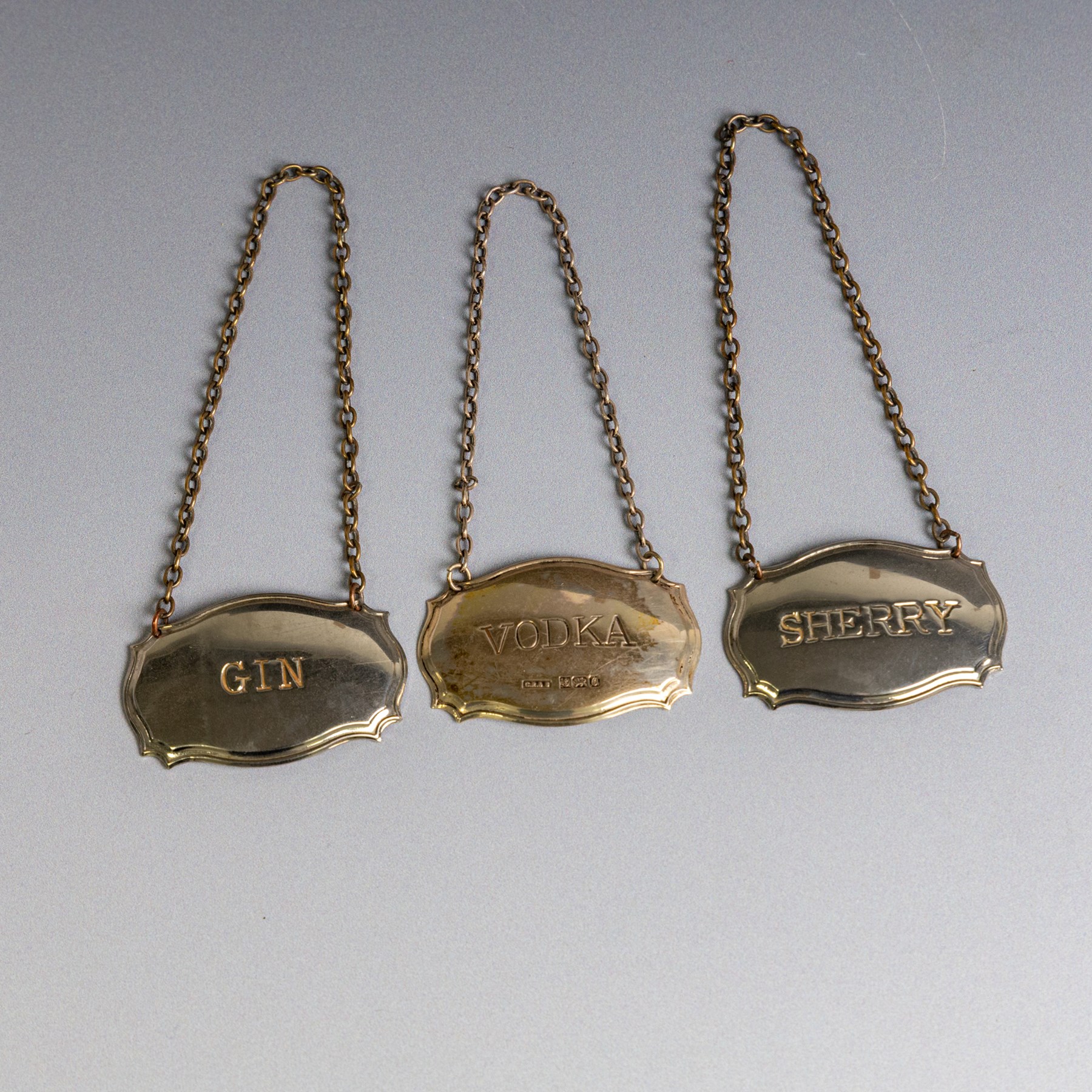 Five silver decanter labels, of varying design, including Bacardi, Vodka, Rum, Brandy and Whisky, all hallmarked together with two silver plated Gin and Sherry examples