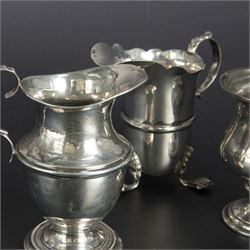 Group of early 20th century silver, comprising sauce boat, with flying scroll handle and upon three pad feet, two small cream jugs and a christening mug, all hallmarked, tallest H10cm