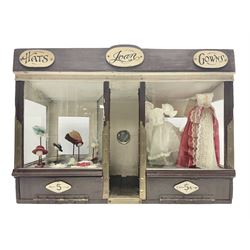 Early 20th century scratch-built wooden hat & gown shop diorama 'Joan', of double-fronted form glazed on three sides with brass and aluminium mounts, rear access apertures and storage under L63cm H45cm D31cm; with small collection of dresses and hats on display stands