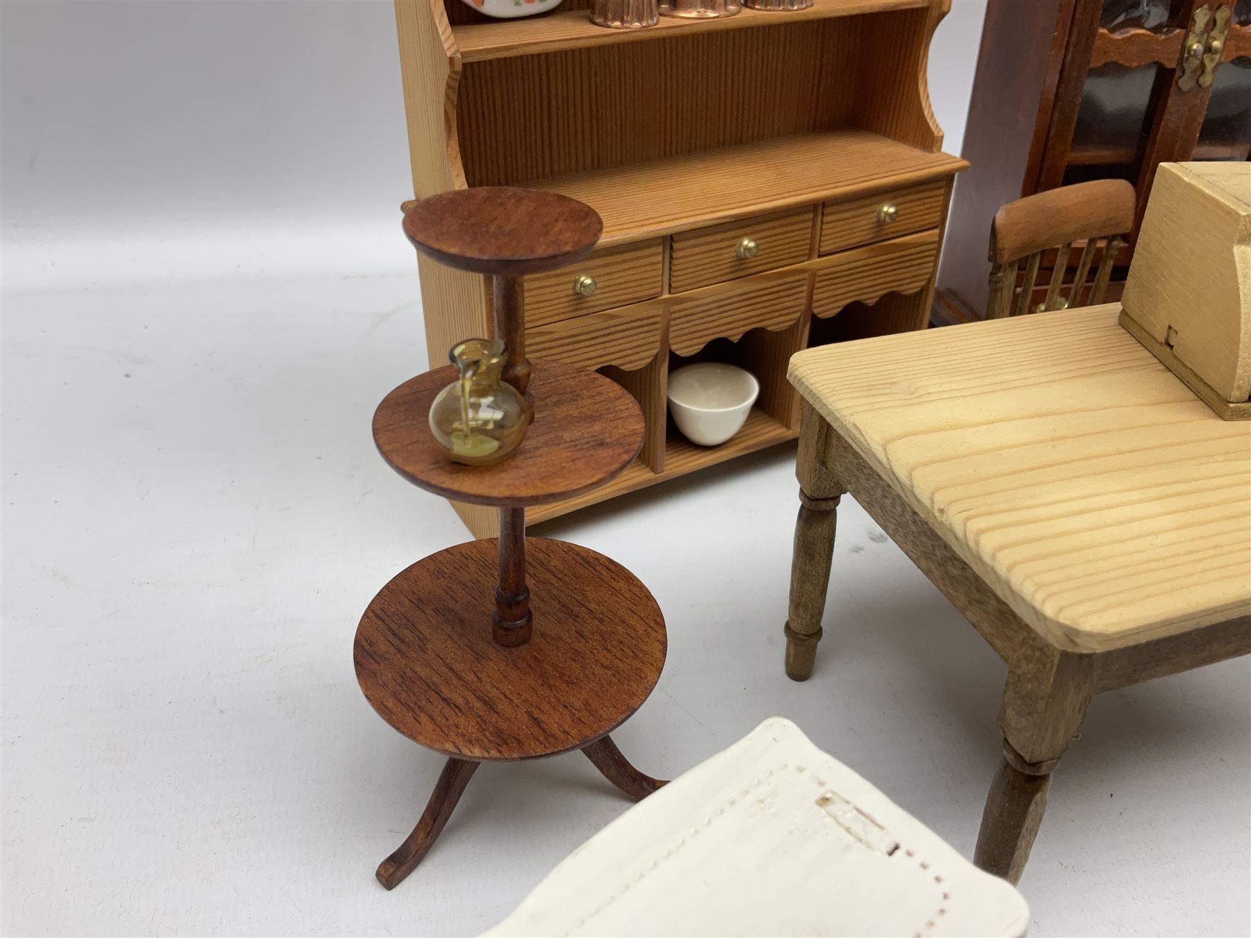 Doll's house wooden furniture - over twenty items including good quality pine Welsh dresser by Tony of Lincoln; tall 'glazed' bookcase; two-tier side cabinet; grand piano; bedside chest, mule chest, Canterbury; cradle; Georgian style hanging corner cupboard; dumb waiter; tables; chairs; rocking chair etc; various scales