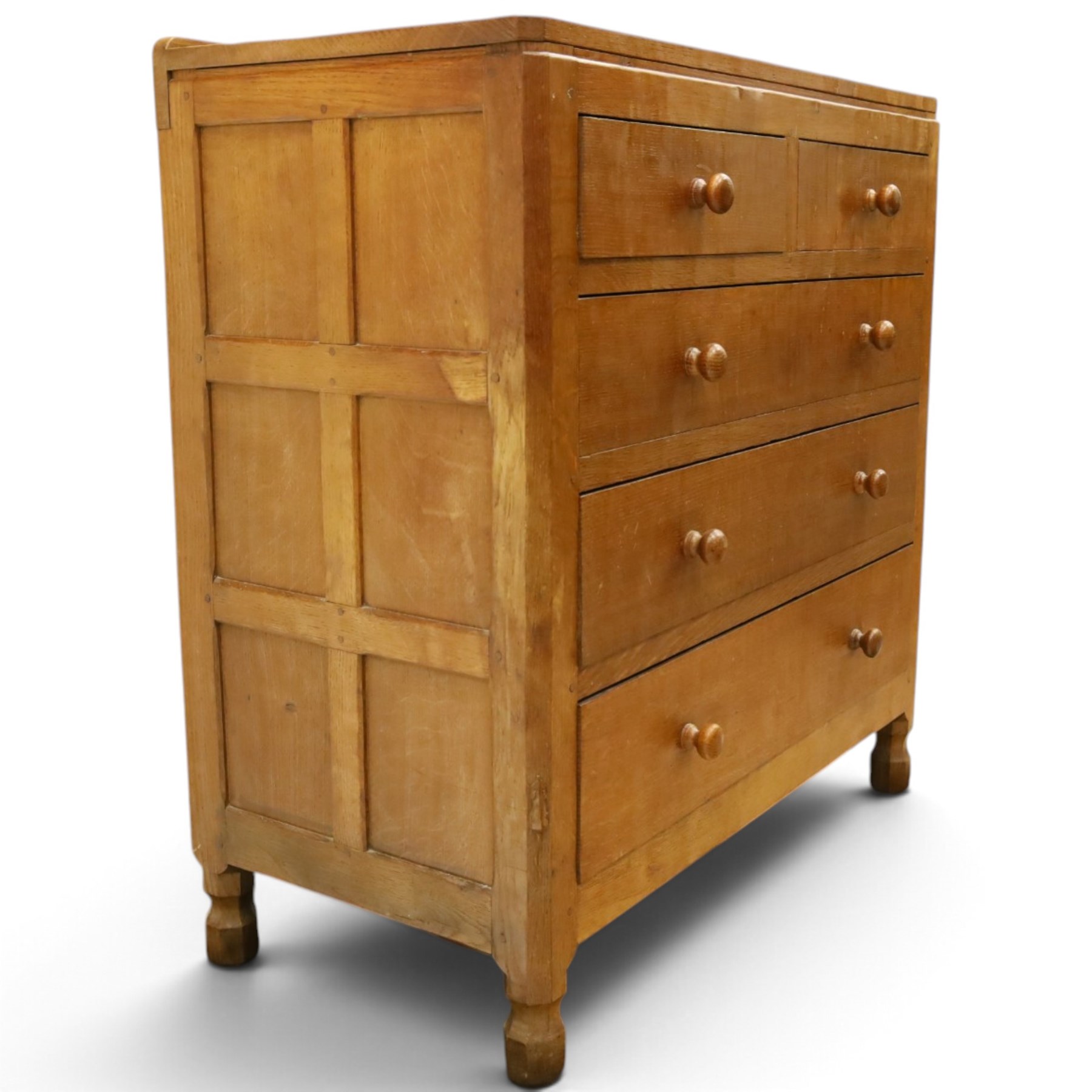Mouseman - early-to-mid 20th century adzed and panelled oak chest, raised back over rectangular adzed top with canted corners, fitted with two short over three long drawers with turned knob handles, raised on octagonal feet, with carved mouse signature, by the workshop of Robert Thompson of Kilburn