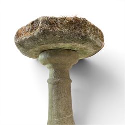 19th century weathered sandstone birdbath, the octagonal canted dished top raised on a ring turned flared pedestal, with four carved stylised dolphins to the squared base