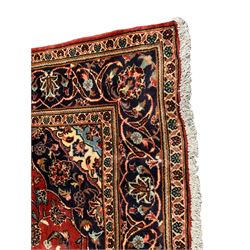 Persian Ardakan crimson ground rug, the field with shaped floral design medallion surrounded by curled leafy branches, scrolling border with stylised plant motifs