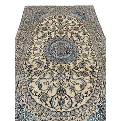 Persian Kashan ivory ground rug, central medallion surrounded by scrolling leafy branches and stylised flowerhead motifs, scrolling border decorated with further stylised plant motifs