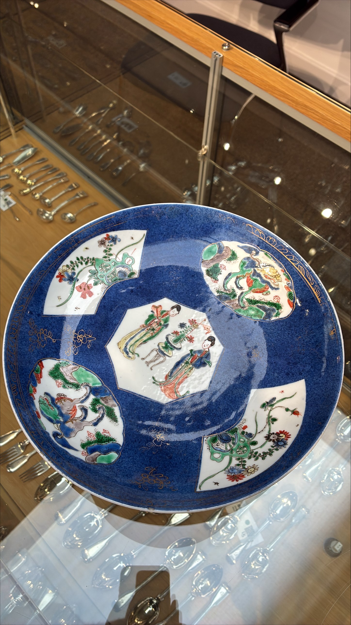 Chinese powder blue ground famille verte charger, possibly Kangxi, decorated with a central cartouche enclosing two female figures, with smaller shaped panels enclosing lions and foliage, square seal mark in blue to base, D28cm