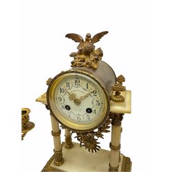 A late 19th century French portico clock with a pair of matching double light candelabra, eight-day outside countwheel movement with recoil escapement, backplate stamped “A.D. Mougin, Paris”, striking the hours and half-hours on a bell, foliate cast bezel with bevelled convex glass, white enamel dial with upright Arabic numerals and minute track, floral garlands and gilt Louis XV hands, gilt drum case surmounted by a small ormolu bird taking flight, raised on four ringed pillars with ornate capitals on a stepped white marble plinth with ormolu mounts, paw feet and gadroon border, pendulum bob with a decorative sunburst mask, pair of matching single column candelabra on a circular marble plinth with two festooned scroll branches and lights plus ormolu mounts and swags. 