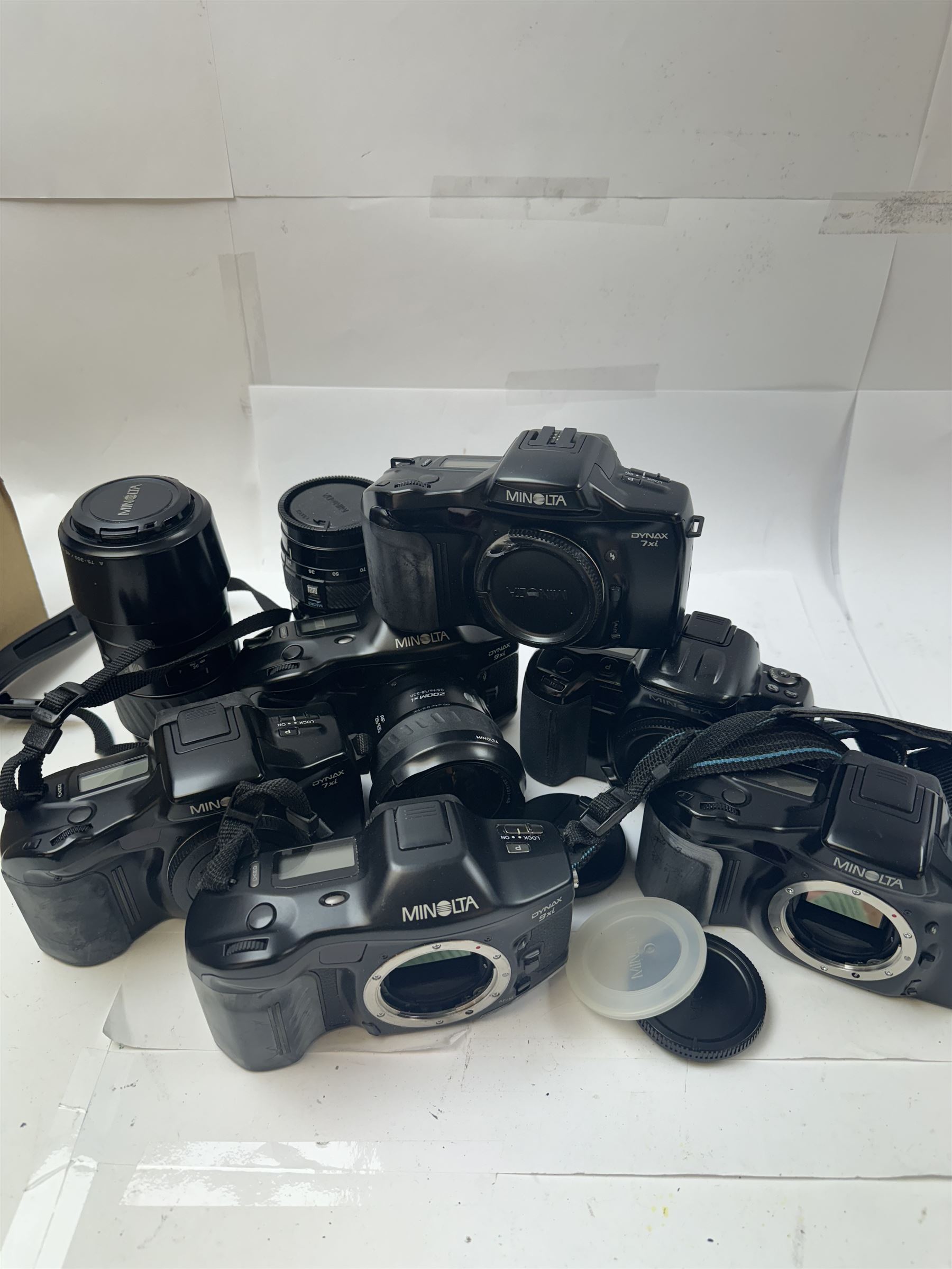 Six Minolta Dynax SLR camera bodies, comprising 800si serial no. 62703606, three 7xi examples, including one boxed example, serial nos. 20106944, 16123311 & 22107553, and two 9xi examples, serial no. 18209901 & 18202113, with three Minolta lenses, including Zoom xi 28-105mm 1:3.5(22)-4.5 lens, AF Zoom 28-85mm 1:3.5 (22)-4.5 lens and an AF Zoom 75-300mm 1:4.5(32)-5.6 lens, Hama carry case and other accessories