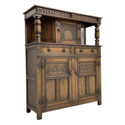 Jacobean design oak court cupboard, upper section with carved arched panelled cupboard door flanked by turned columns, beneath carved and moulded frieze, lower section fitted with two drawers over two cupboard doors with gothic arched panel decoration, raised on stile supports
