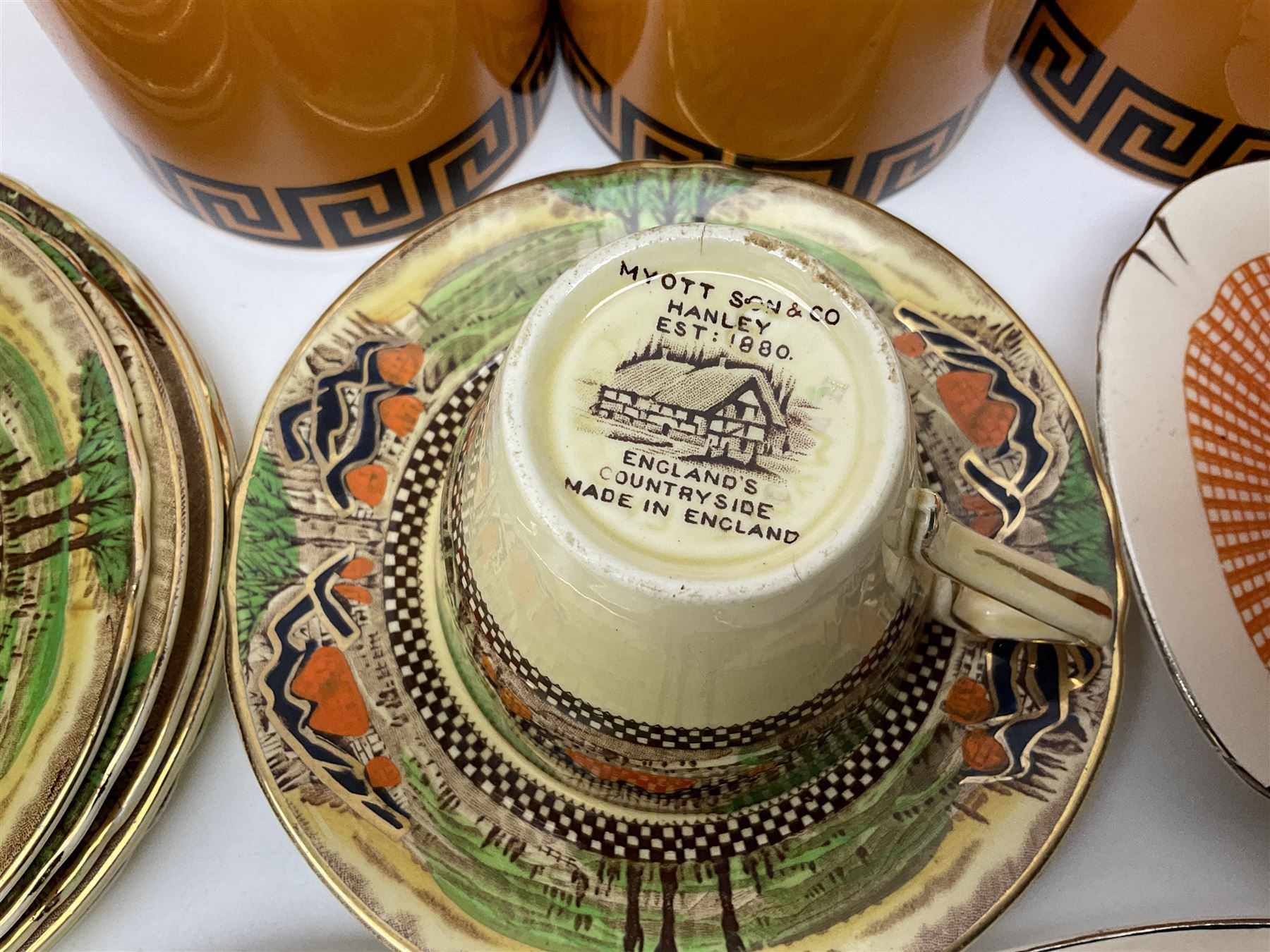 Four Portmeirion storage jars with Greek key pattern on an orange ground, together with Tams Ware tea service and other ceramics