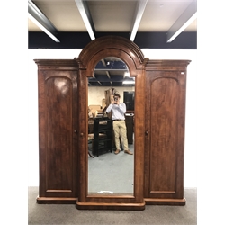  Victorian mahogany triple breakfront wardrobe with arched top, projecting cornice, three doors with single full length mirror enclosing four linen slides and five drawers, plinth base, W220cm, H231cm, D75cm  