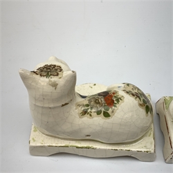 Pair of 19th century Staffordshire cats, modelled in recumbent pose, upon bases with bracket feet, later decorated with transfer printed flowers, H12cm 