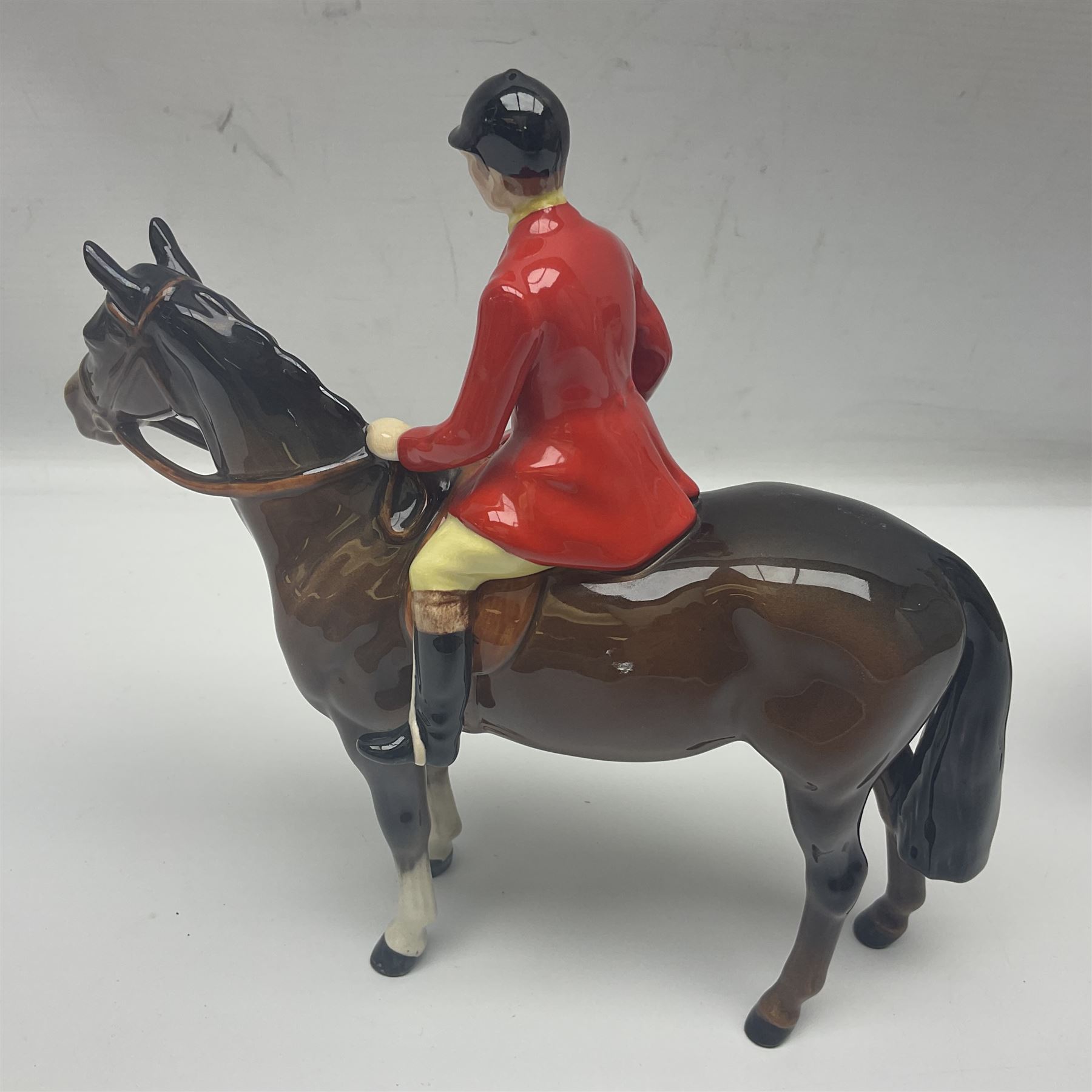 Beswick hunting group, comprising huntswoman on grey horse no 1730, huntsman on brown horse no 1501, fox figure no 1440 and eight fox hounds, all with printed marks beneath (11)