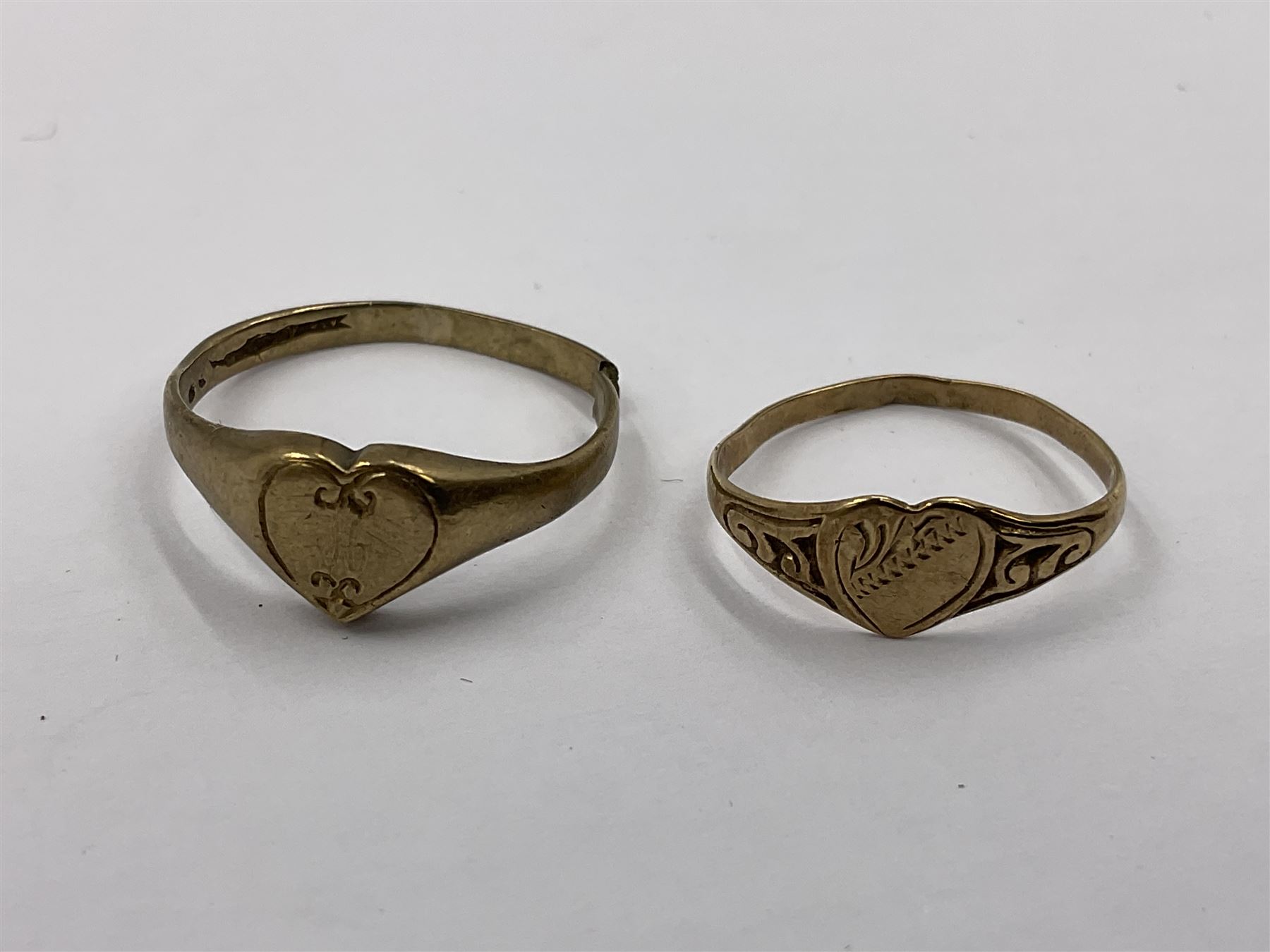 Four 9ct gold rings, to include cubic zirconia wishbone ring, single stone cubic zirconia ring and two heart design signet rings