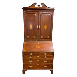 George III mahogany bureau bookcase with later Edwardian inlays, the broken swan neck pediment with boxwood stringing a an oval acorn and oak leaf motif, the two panelled doors with shell inlay enclosing two shelves, the fall-front enclosing fitted interior over two short and three long graduating cock-beaded drawers, on bracket feet
