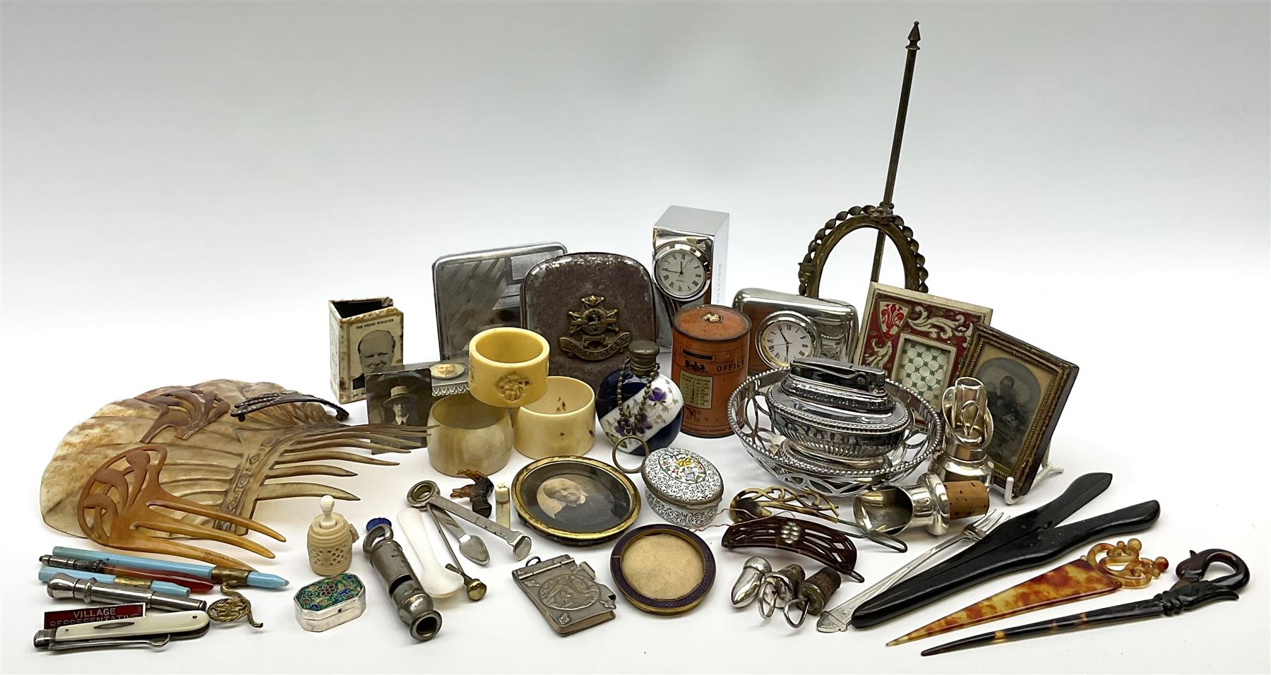 A group of assorted collectables, to include small oval purple guilloche enamel frame, WWII matchbox holder depicting Winston Churchill, Halcyon Days enamel box, Ronson table lighter, ebonised glove stretchers, ivory napkin ring, mother of pearl handled button hook, engine turned cigarette case, etc. 