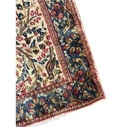 Small Persian Kirman ivory ground rug, tree of life design and decorated with birds, the triple band boarder decorated with floral motifs and birds