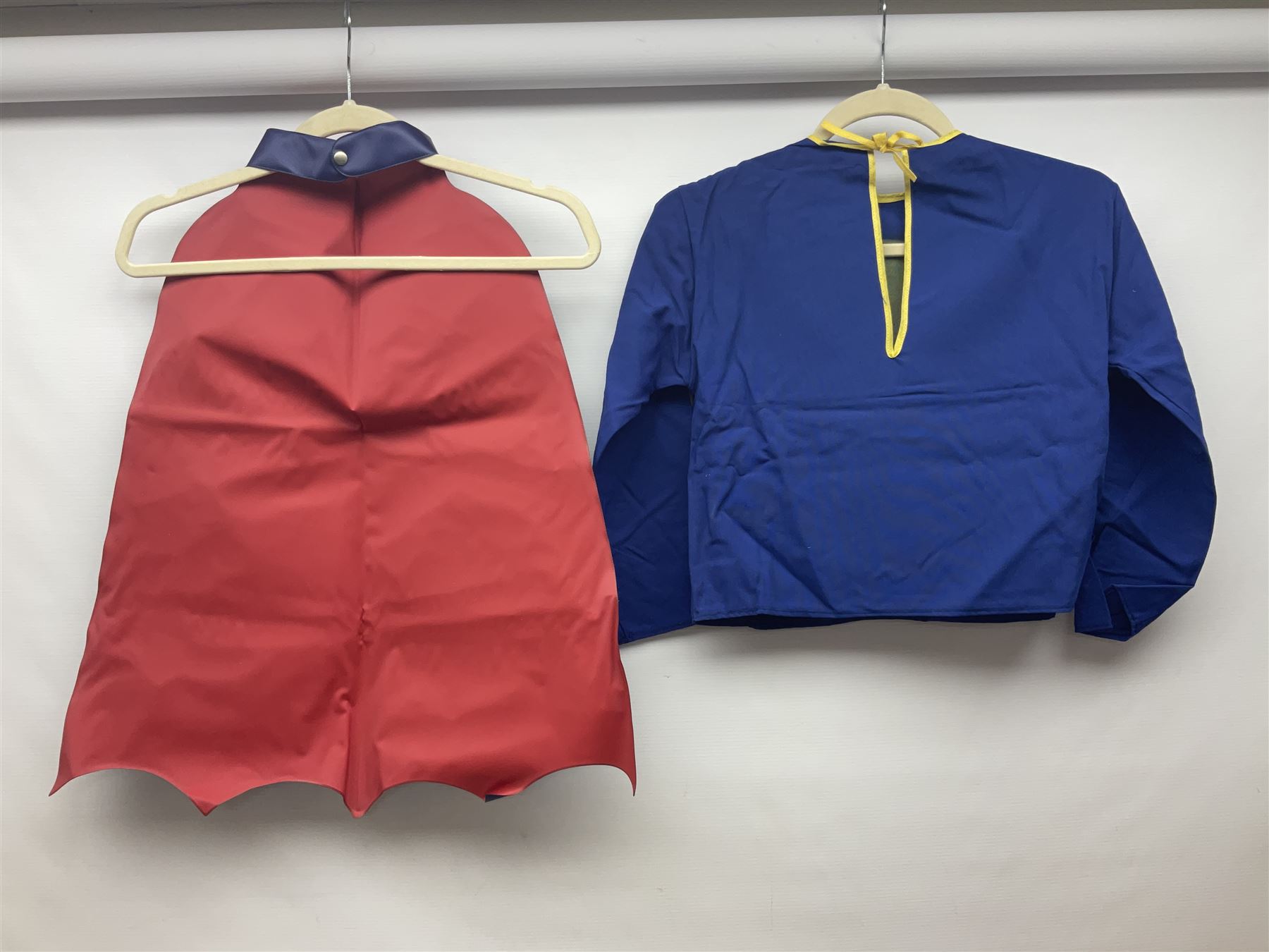 Two Boxed Batman Playsuit Costumes - 1960s 20th Century Original Play Suit, black eye mask, plastic vinyl cape/gauntlets, leather style belt, blue/yellow shirt, with Bat motif and blue/yellow pants; in original illustrated lidded box; and 1976 Decker Batman Playsuit costume, vinyl cape/ mask/gloves/boot tops/yellow belt, grey cloth top and pants; in original illustrated box (2)