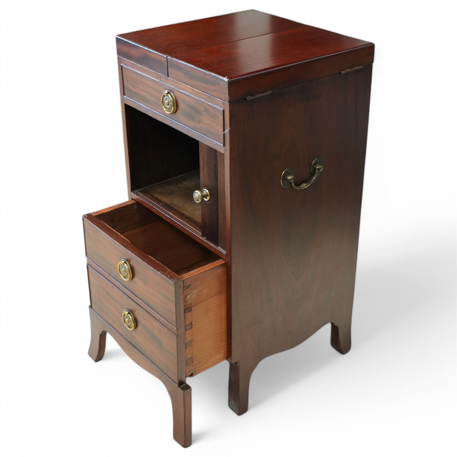 Early 19th century and later mahogany washstand, the dual-hinged fold-out top, over a cupboard enclosed by tambour roll, fitted with deep drawer to base disguised as two cock-beaded drawers, on splayed supports