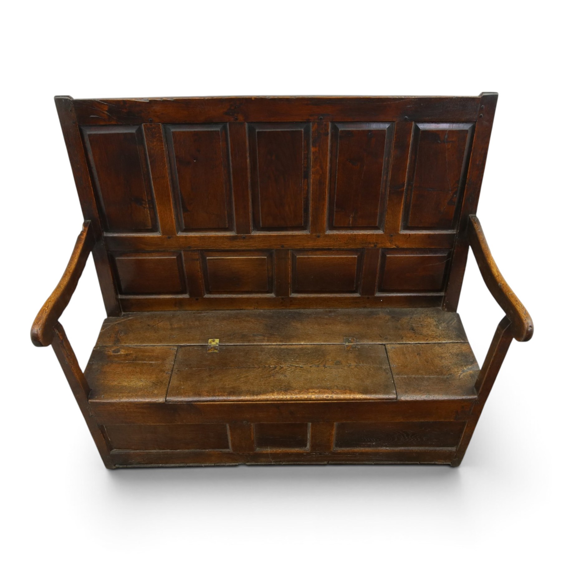 18th century oak high-back settle or hall bench, the panelled back and arm terminals over a hinged box seat, panelled front on short stile feet