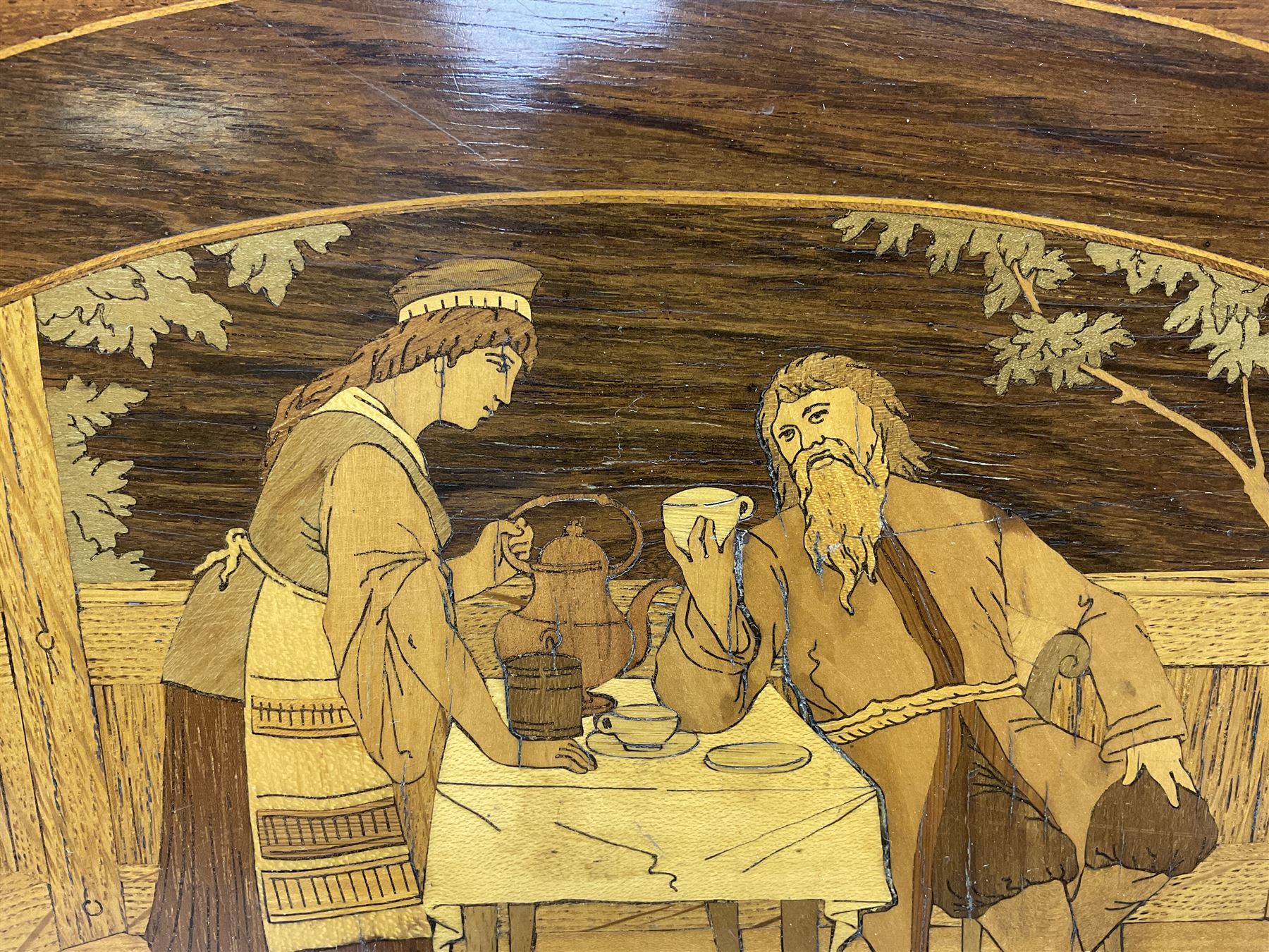 Late 19th/early 20th century mahogany and marquetry inlaid tray, of oval form with twin scrolled handles and moulded border, the central panel inlaid with figures seated at a table drinking tea, L99cm