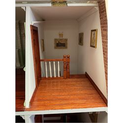 'The Hollies' - good quality sectional wooden doll's house in the form of a Georgian style four-storey bay windowed town house with simulated brick front elevation, rendered sides, off-set corner stonework, faux slate-hung top floor with flat roof and chimney stack, working sash windows, iron railings around front basement courtyard with hinged front elevation to two rooms with  spiral staircase, side hinged central section approached by external steps with iron balustrades to the sides leading to a front door, entrance hall with stairs to landing and two rooms on two floors with dado panelling and fire-surrounds, the top floor with top hung front elevation revealing stairs to a landing and bedroom; wired for electricity L51cm D65cm H107cm including chimney; together with a good quantity of quality wooden furniture and accessories including piano, dressers, bookcase and books, rugs, double half-tester bed, metalware, pictures etc