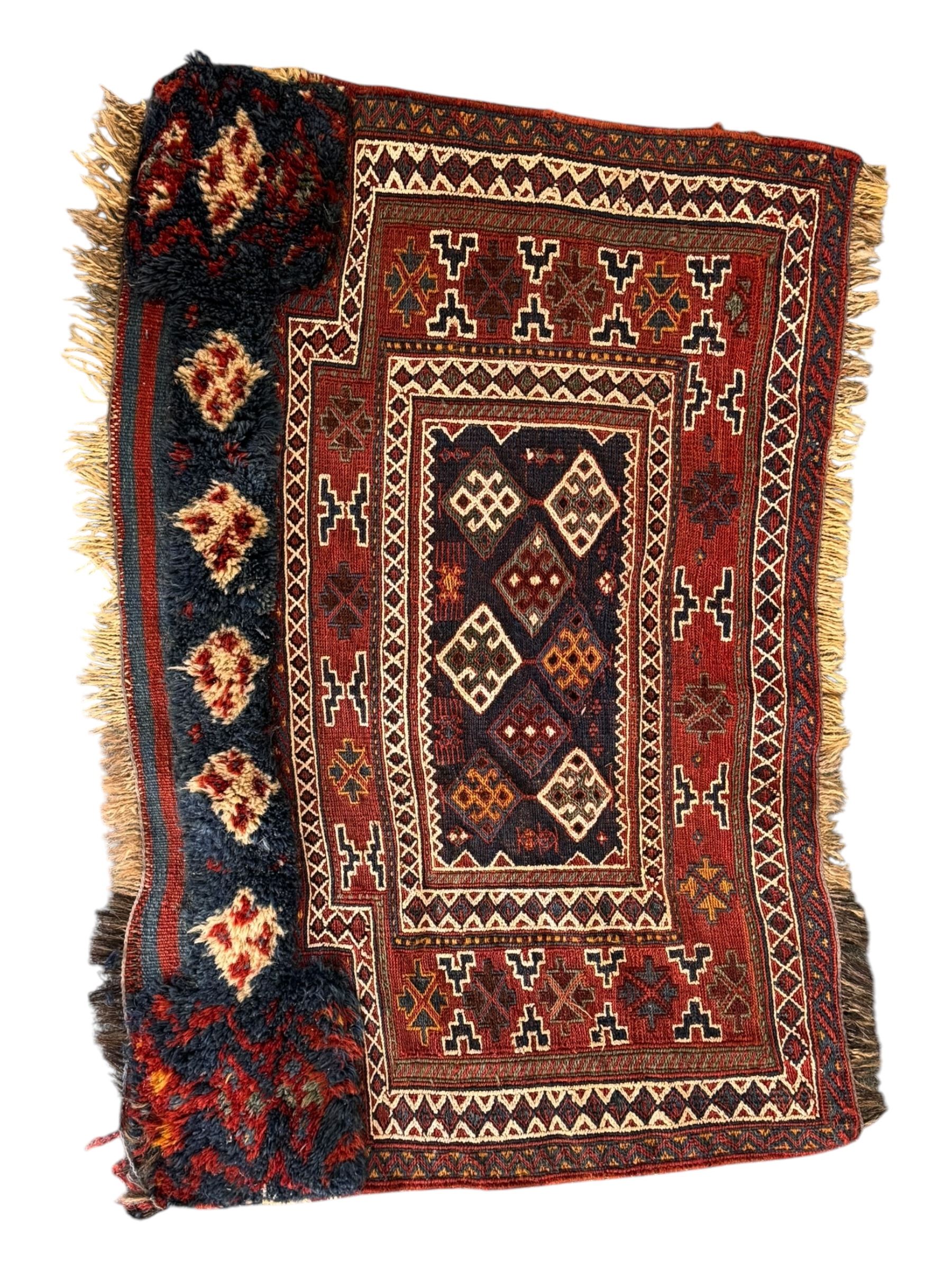 Persian-style wool rug, cream field with floral and geometric motifs, wide floral border (74cm x 142cm); Persian wool rug, beige field with dense floral patterns, narrow floral border (70cm x 144cm); Tribal wool rug, red and navy with diamond motifs (96cm x 60cm); Persian pictorial wool rug, black field with vase, birds, and floral border (70cm x 73cm)