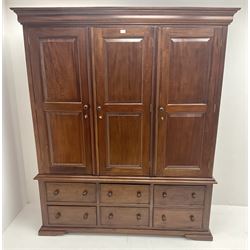 Mahogany triple wardrobe, projecting cornice, three doors above four drawers and single faux drawers cupboard, shaped platform base