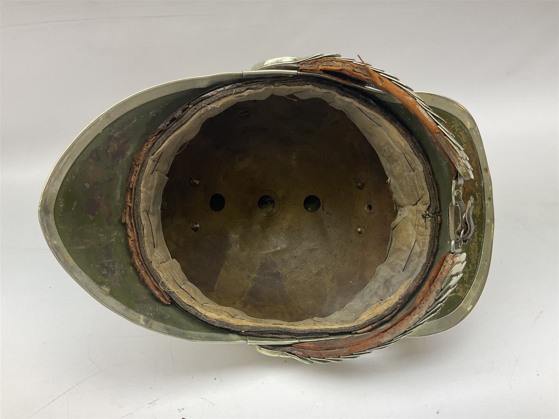 Early 20th century French mounted gendarme's helmet, brass with nickel-silver mountings, broad band embossed with fused grenade, high comb with the face of the gorgon Medusa at the peak and with a black horse hair crest, plume socket at the left, leather-backed nickel-silver chin scales with lion mask mounts.