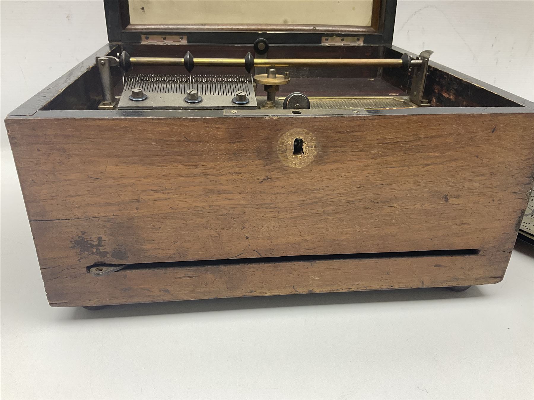 Late 19th century Symphonion disc musical box for spares or repair, inlaid walnut case with front lever action, playing 25.5cm discs on a 10.5cm steel comb with forty-nine teeth, musical scene of cherubs under the lid, L33cm; together with twelve 25.5cm discs