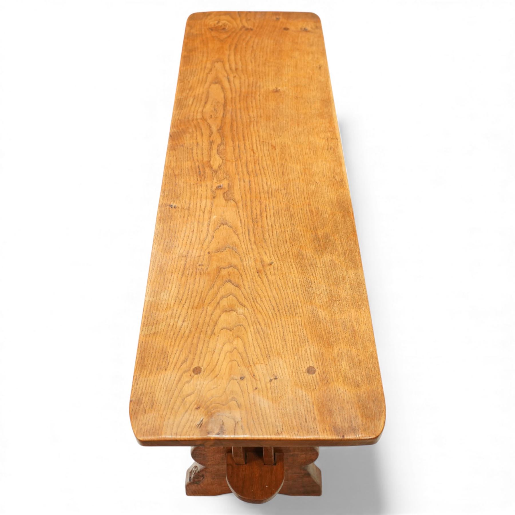 Gnomeman - oak rectangular coffee table, the thick plank top with exposed pegged joints, raised on shaped slab ends united by a lower undertier, carved with the signature gnome to one support, by Thomas Whittaker of Littlebeck