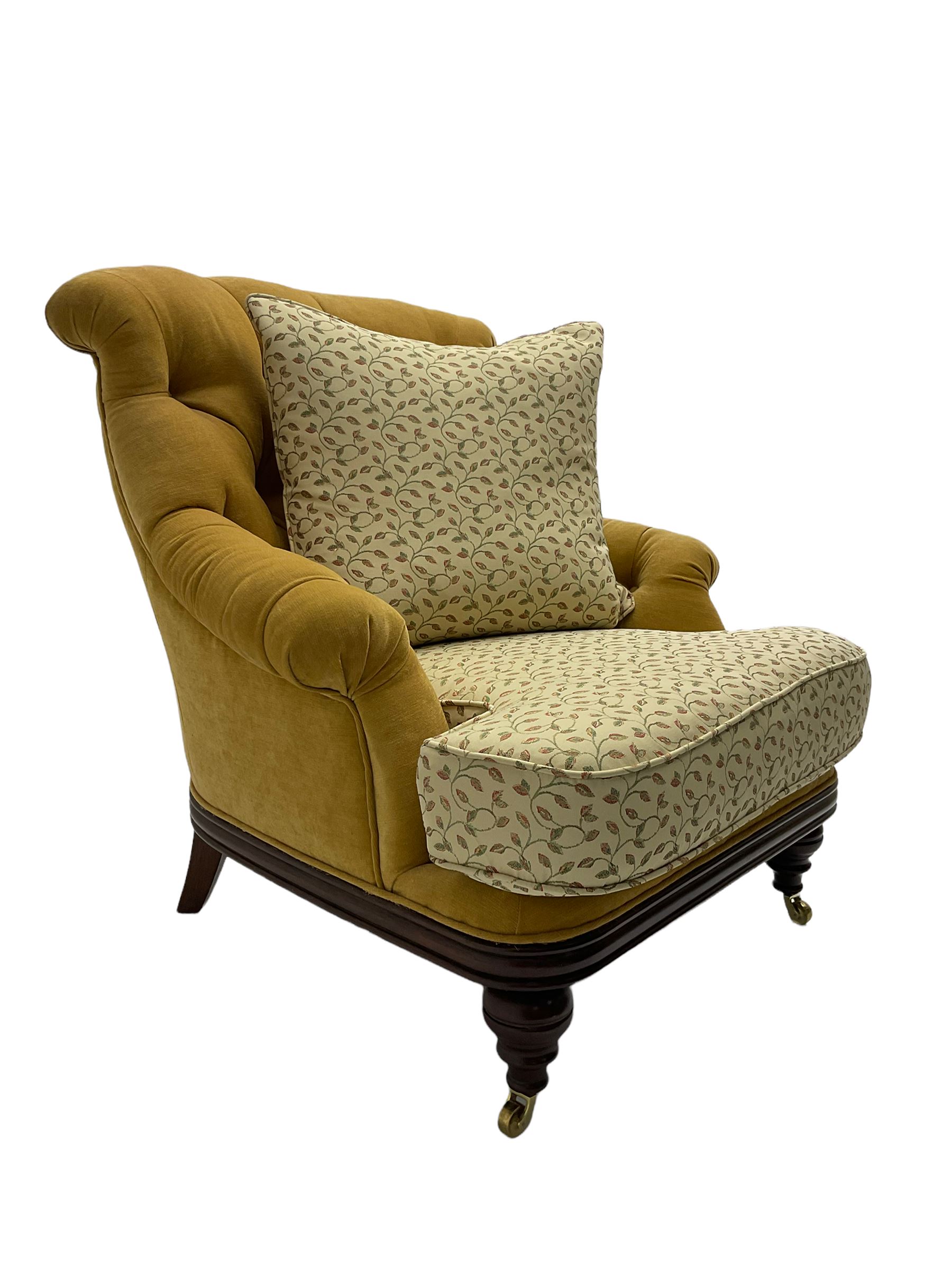 Victorian style armchair, upholstered in buttoned fabric with contrasting foliate pattern seat and scatter cushion, on turned front feet with castors