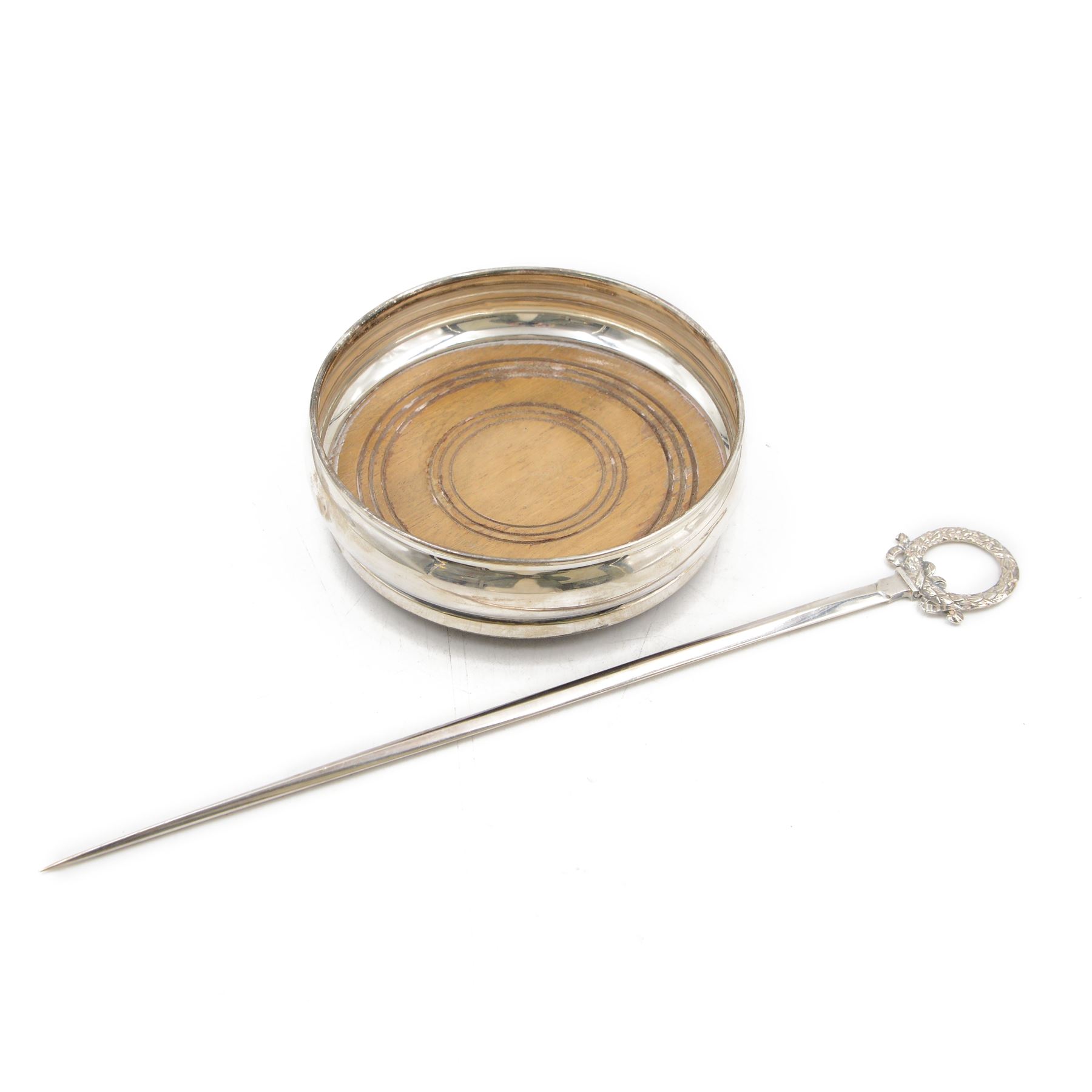 Edwardian silver meat skewer, with wreath loop handle, hallmarked James Dixon & Sons Ltd, Sheffield 1902, together with a late 20th century silver mounted bottle coaster with turned wooden centre, hallmarked W I Broadway & Co, Birmingham 1982, coaster D13cm