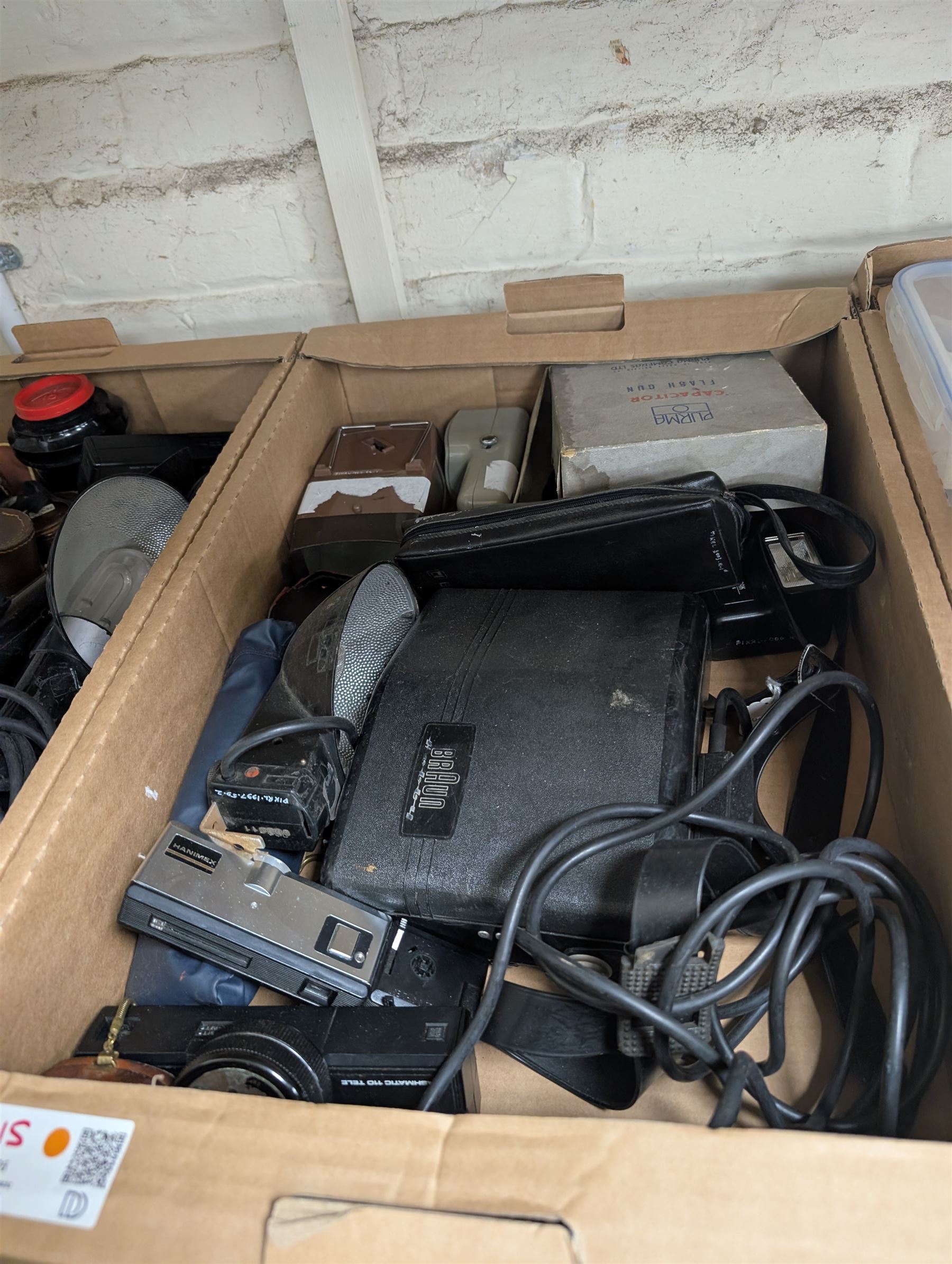 Collection of camera flashes and light meters, including Weston Master light meters, Braun Hobby flash, Hanimex XP1, in two boxes
