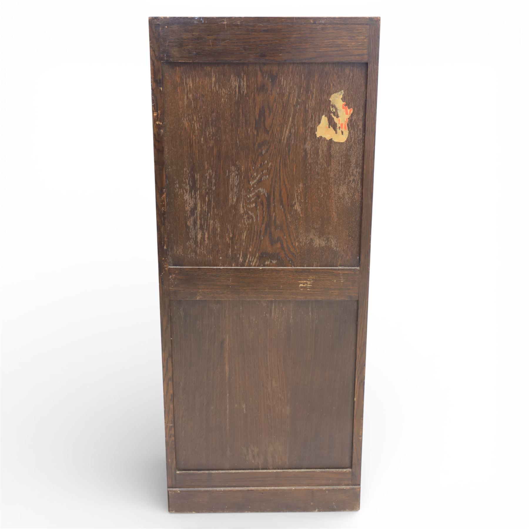 Early 20th century oak tambour front fitted cabinet, rectangular top with rounded corners over a roll tambour front enclosing a fitted interior of multiple shallow drawers with cut-out pulls, the sides with rounded uprights, on a stepped plinth base