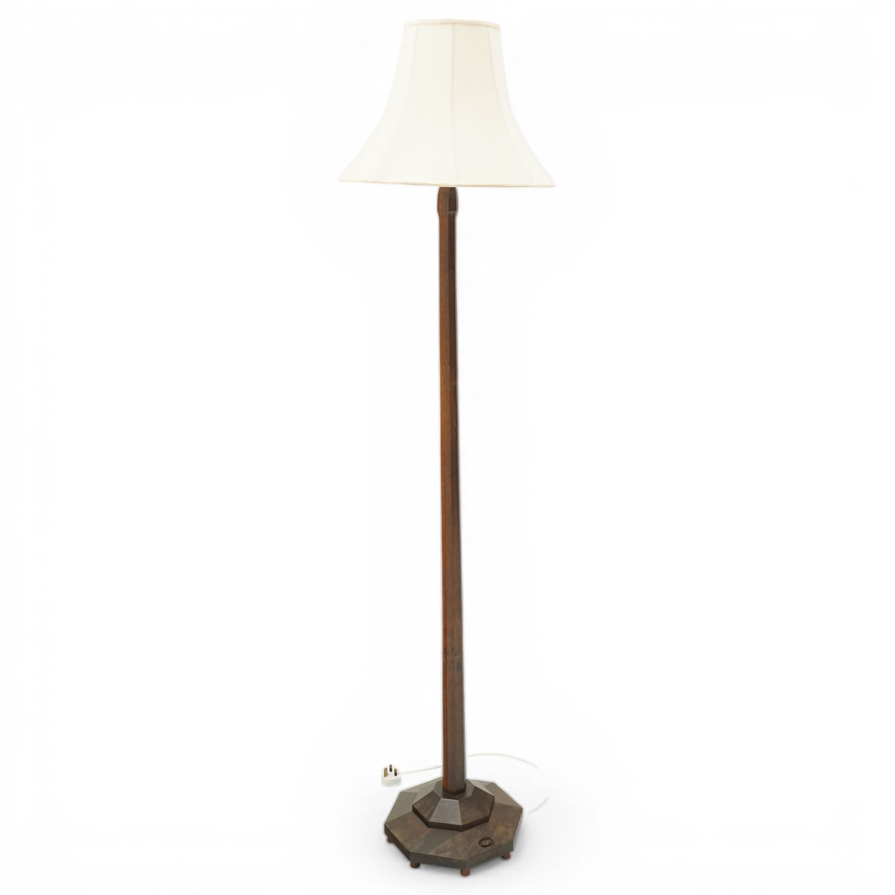 Acornman - dark stained oak standard lamp, supported on an octagonal column terminating in an octagonal base, with carved acorn signature, by the workshop of Alan Grainger of Brandsby 