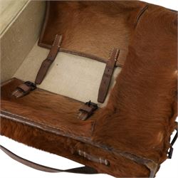 Swiss army pony skin backpack, with rolled leather edges and leather straps, the back straps stamped with Swiss cross over Sch., the fascia enclosing two belted flaps, with cream canvas lining, H38cm, W37cm