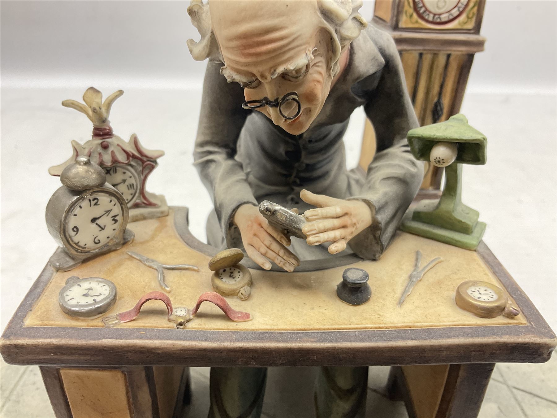 Two Capodimonte figures, comprising The Watchmaker by Curiase and Tramp Seated on a Bench, created by D.Bonalberti, tallest example H24cm
