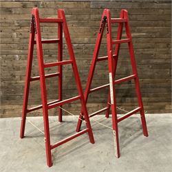 Pair of vintage red painted A frame trestles, with original A W Oates Painter signage