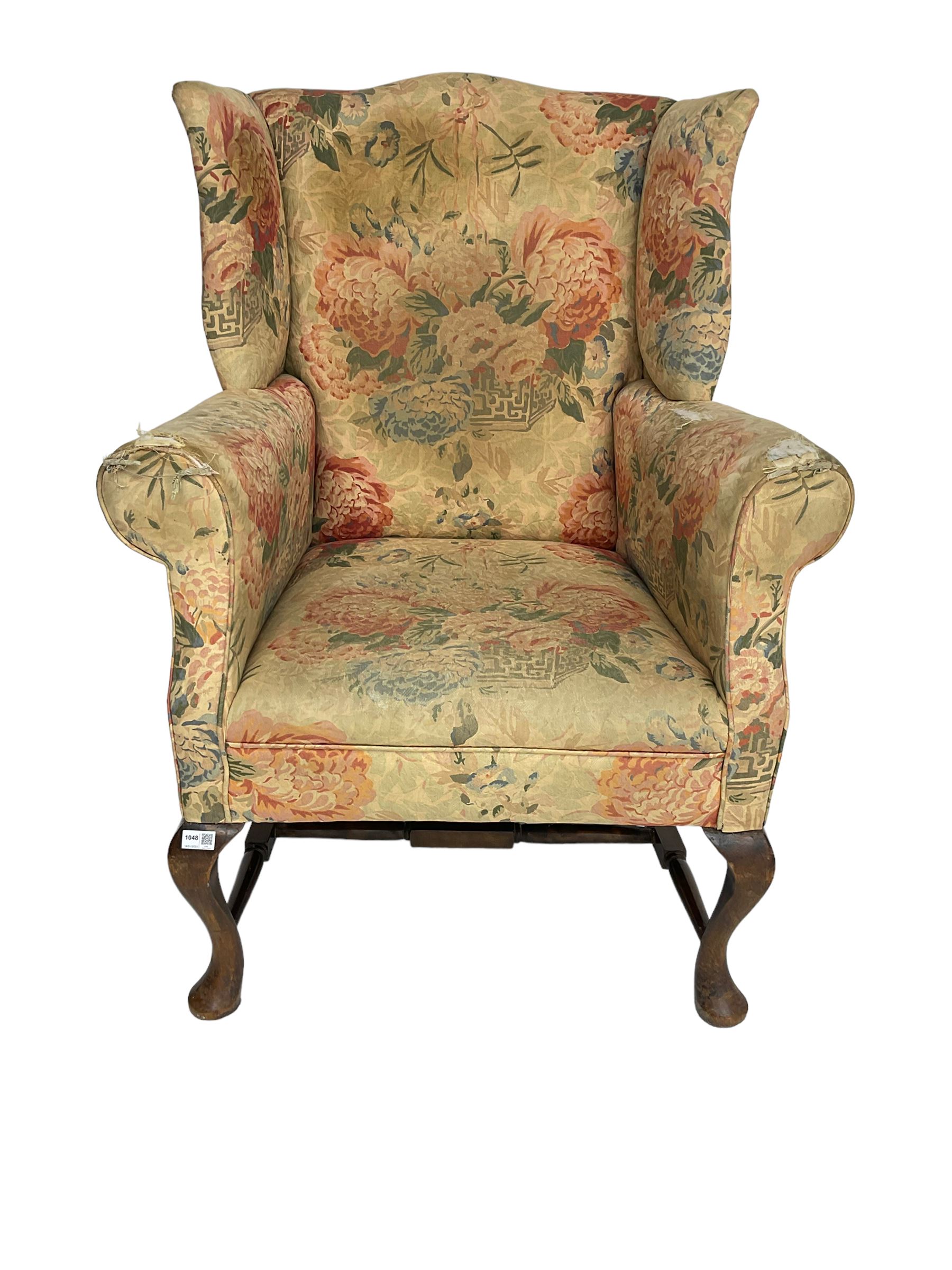 Early 20th century Georgian style wingback armchair, upholstered in floral fabric with sprung seat, walnut frame with front cabriole supports