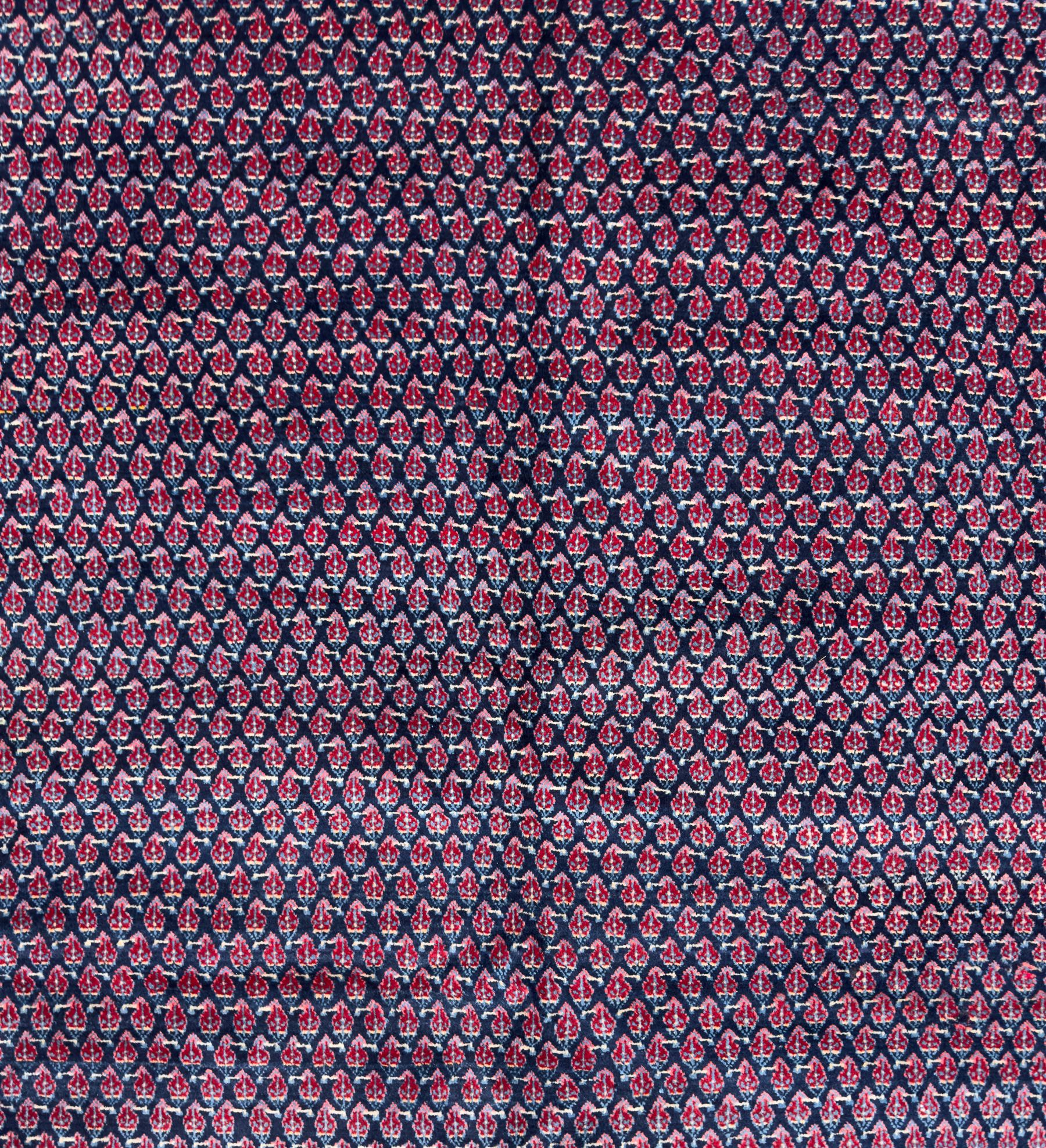 Northwestern Persian Bottehmir hand-knotted carpet, dark indigo field with an all-over design of boteh motifs arranged in diagonal rows, framed by multiple borders, main ivory border with stylized floral sprays between narrow geometric guard stripes, 362cm x 268cm