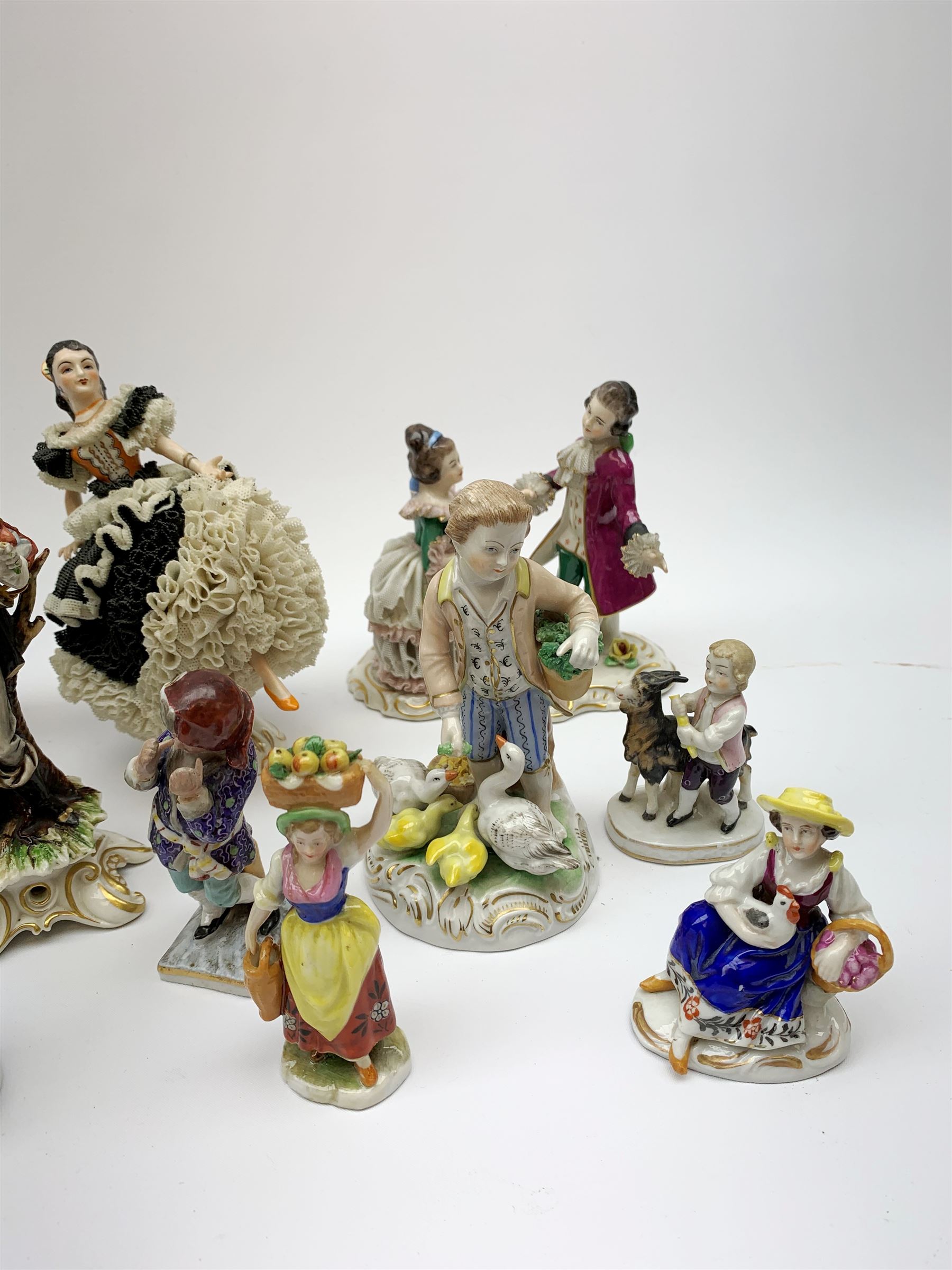 A group of various Continental figures, to include examples marked Dresden and Capodimonte, plus others with spurious blue cross marks beneath. (14). 