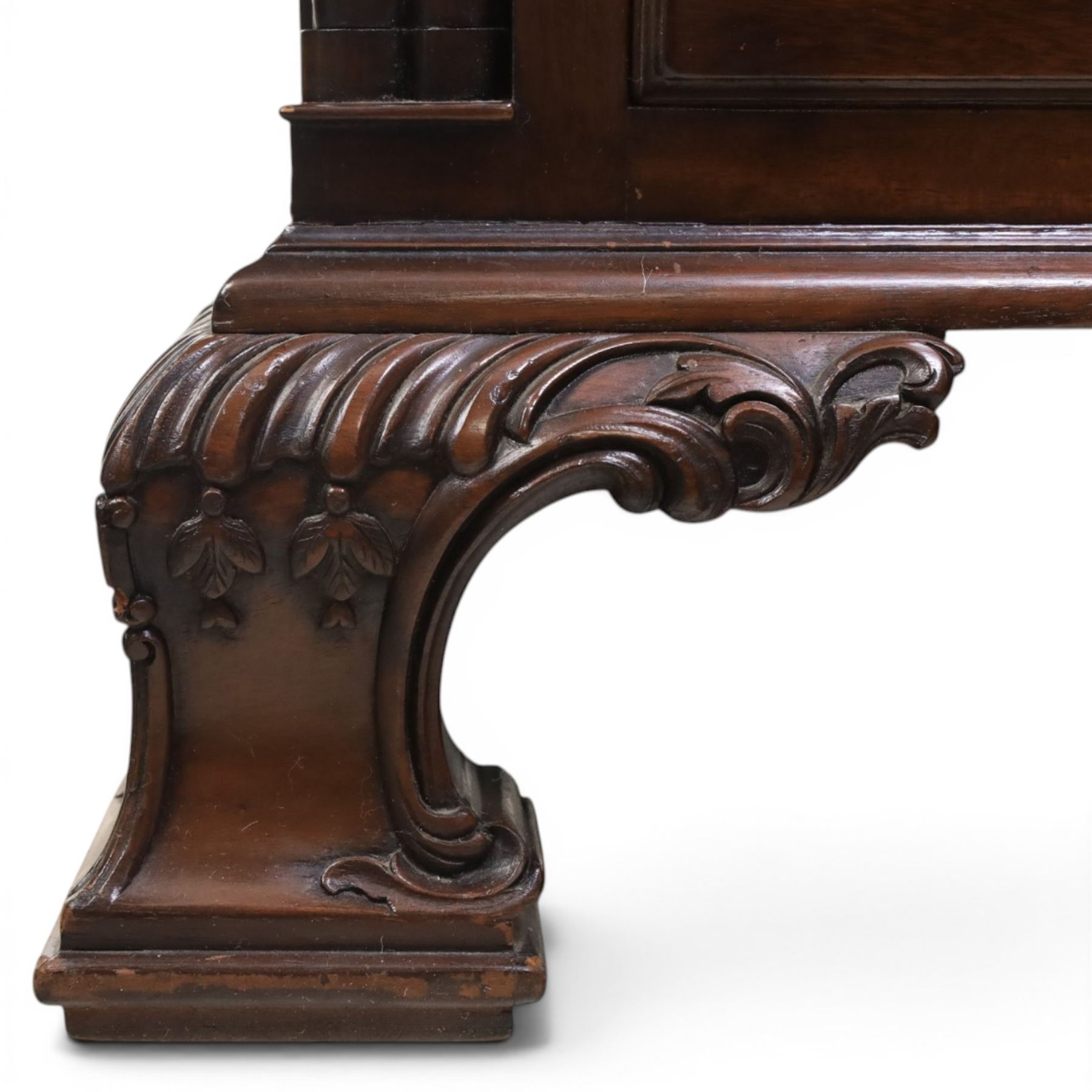 George III style large mahogany reverse breakfront partners desk, red tooled leather writing surfaces crossbanded and moulded edges, flanked by ring-turned cluster columns three frieze drawers with brass swan neck handles, raised on large pedestals with faux drawer fronted cupboard and three graduated drawers, supported on carved ogee feet decorated with C-scrolled and acanthus leaves