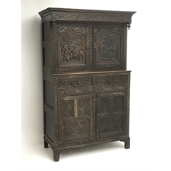  19th century heavily carved oak court cupboard, projecting cornice, blind fret frieze, four cupboard doors depicting ancient fighting scenes, two drawers, W115cm, H184cm, D57cm  