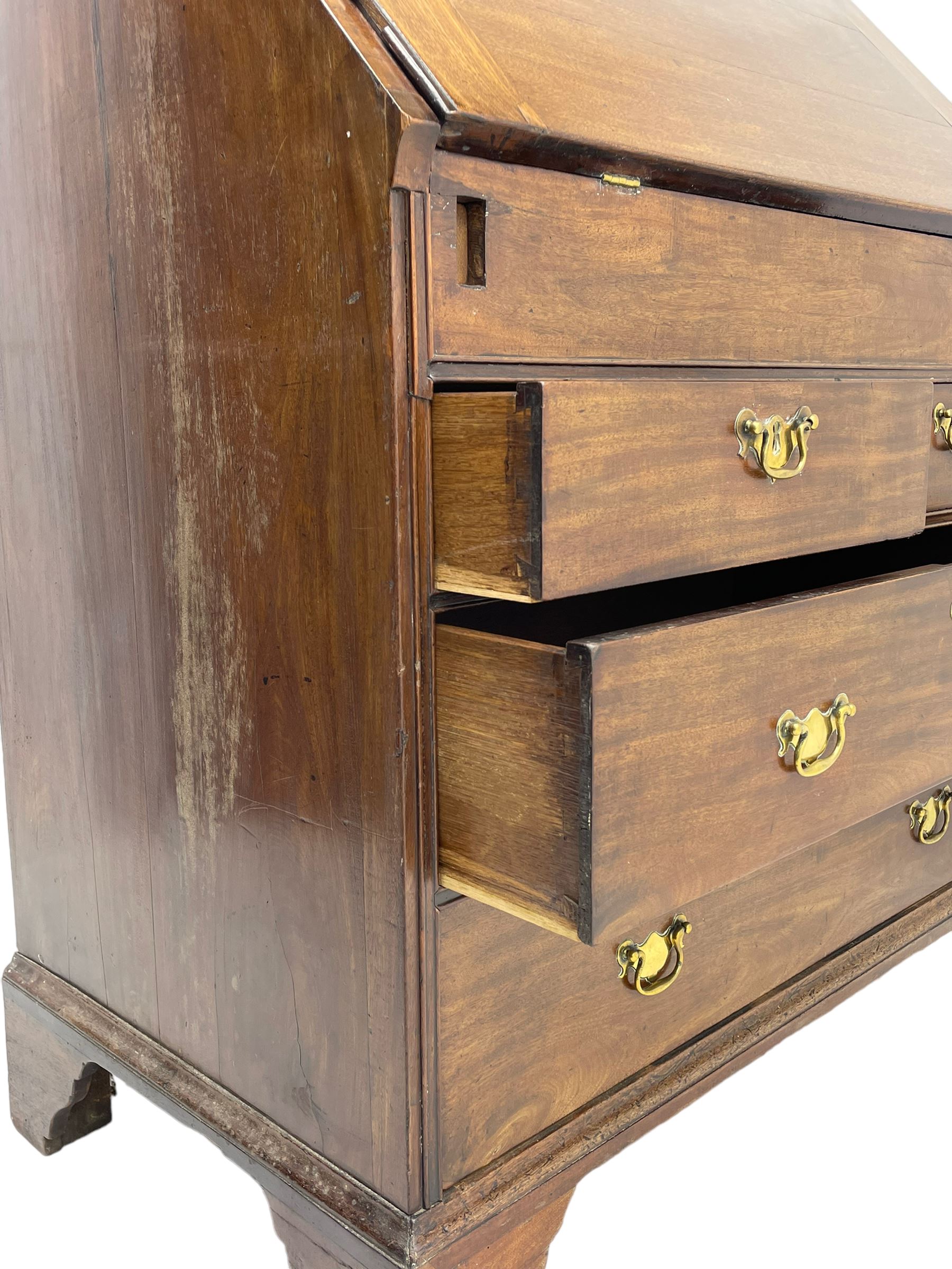 Georgian red walnut and mahogany bureau, moulded rectangular fall front with rounded upper corners, the interior fitted with sliding storage well, a combination of small drawers and pigeons holes, two short and two long drawers below, on bracket feet