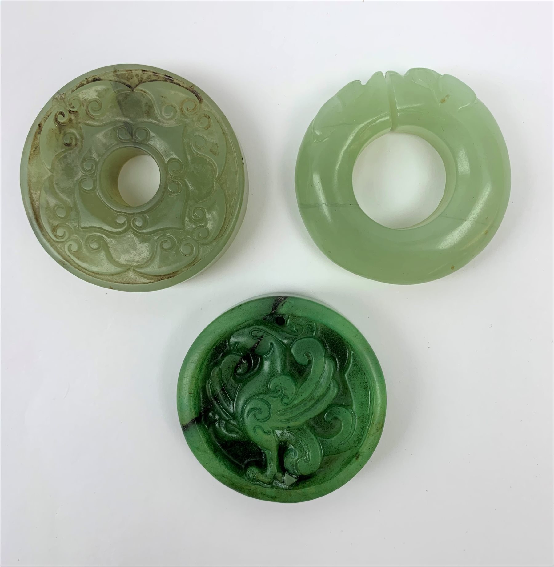 Two jadeite bi discs, largest D5.5cm, together with a nephrite jade