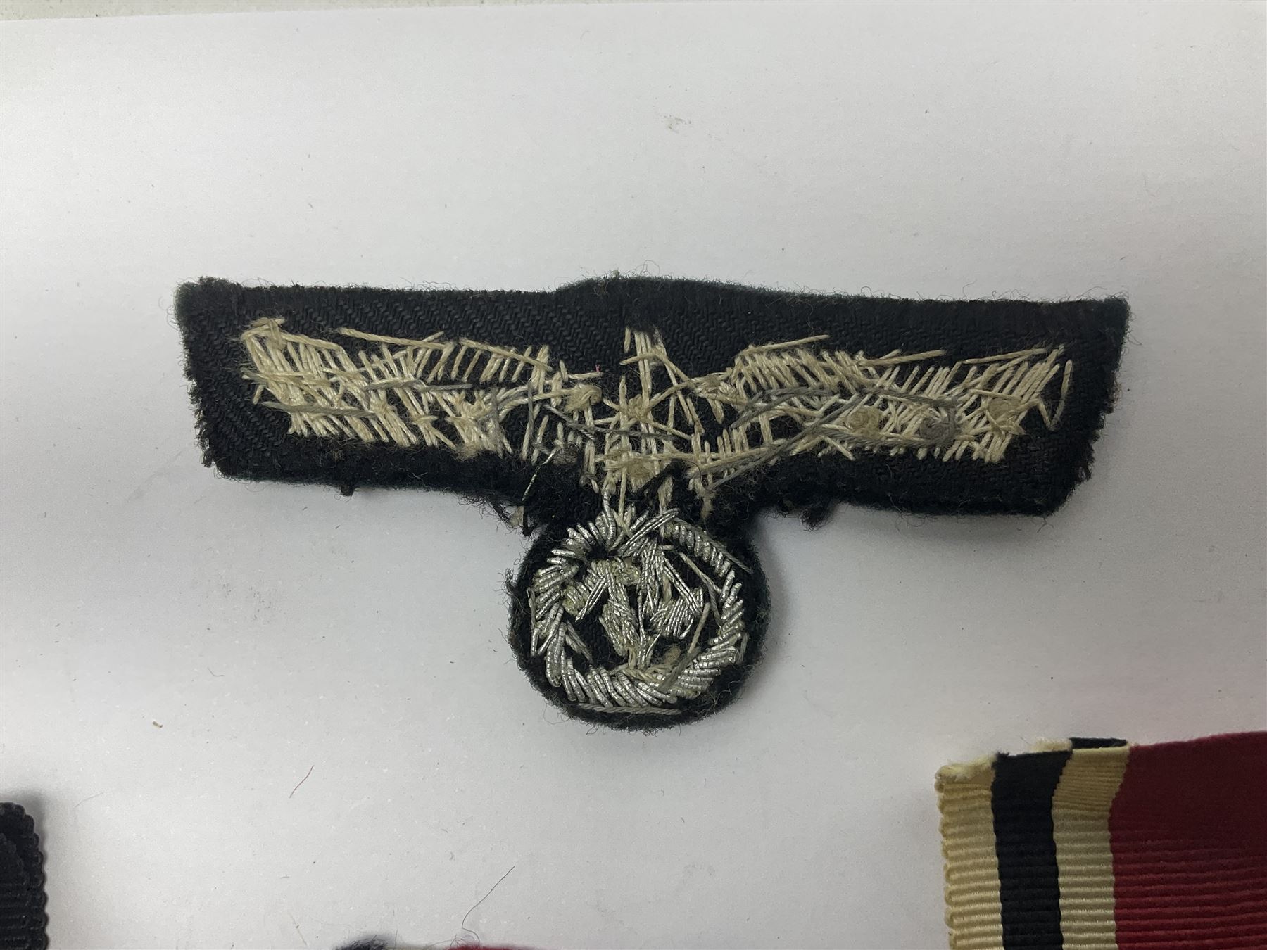 WWII German Iron Cross 2nd Class, the suspension ring stamped 128 for S. Jablonski G.m.b.H. Posen; with ribbon; together with an embroidered cloth eagle badge and quantity of German medal ribbons.