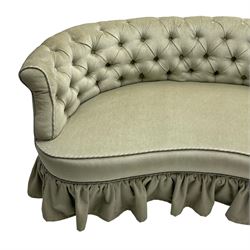 Victorian mahogany framed kidney shaped two seat settee, low curved back and sprung seat upholstered in buttoned pale pearl green fabric with pleated skirt, raised on turned supports with castors
