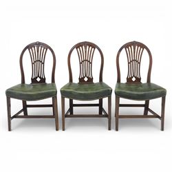 George III style set of six mahogany dining chairs, the arched backs with pierced and carved vase splats beneath carved husk and patera detail, drop-in upholstered seats covered in green leather with brass studded edging, raised on square section legs united by plain stretchers
