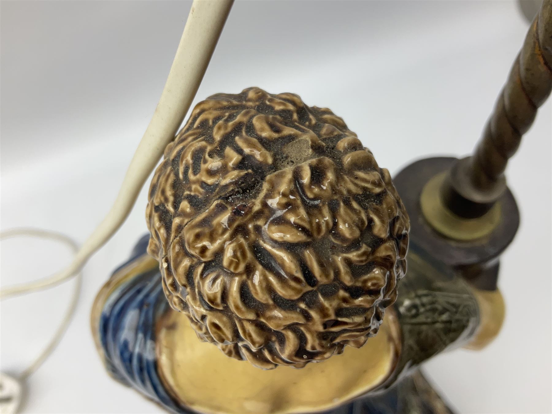 Composite table lamp modelled as a Roman Emperor donning blue robes, upon quatrefoil base modelled with rams heads and winged cherubs, H56cm excl fitting